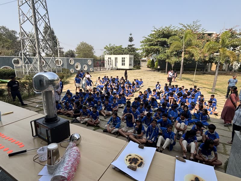 Students seated outdoors watching a Manthan demonstration
